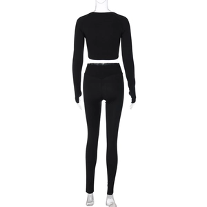 Back view of black slim fit athletic yoga set featuring long sleeve crop top and leggings