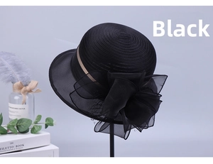 Detail of a black sun hat featuring a large organza bow and elegant champagne ribbon