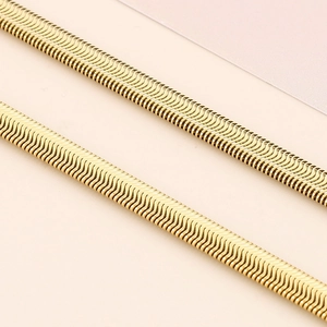 Detailed view of the flat golden snake bone chain with smooth metallic texture