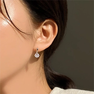 Close-up of model wearing elegant 925 sterling silver four-prong zircon stud earrings