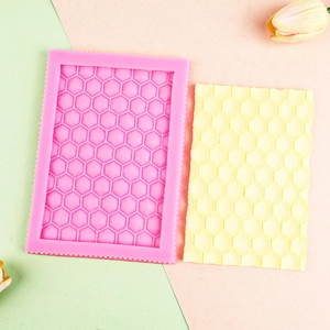 Close-up of pink silicone honeycomb mold with yellow fondant lace cake decoration
