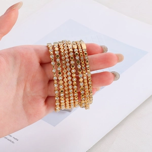Primo piano di sette bracciali in acciaio inossidabile placcato oro 18K con zirconi