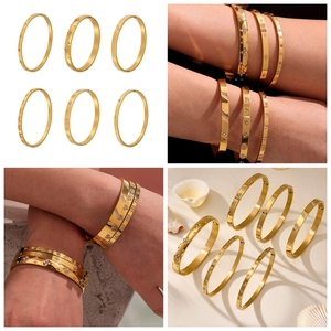 Detail view of gold stainless steel bangle set with zircon inlays on model's wrist