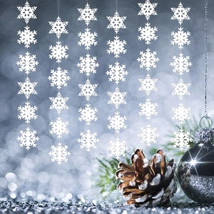 White Christmas snowflake garlands decoration hanging in front of festive blue lights