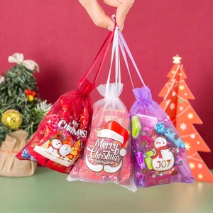 Close-up of three festive organza drawstring bags for Christmas candy and gifts