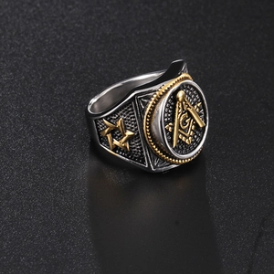 Macro detail of Masonic skull ring with gold and silver relief on brushed metal surface