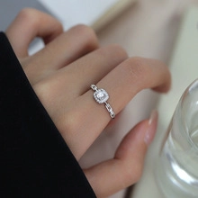 Macro shot of silver chain ring featuring a square-cut pink zircon and polished finish