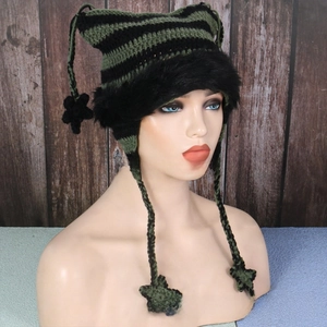 Detail of knit cat ear hat with black-green stripes, faux fur trim and star pendants