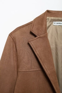 Detailed close-up of brown suede blazer lapel showing fine stitching and inner lining