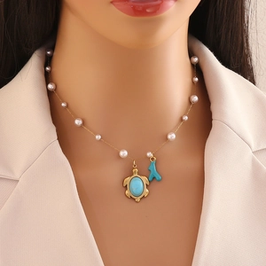 Elegant gold pearl necklace featuring a sea turtle pendant and turquoise coral charm