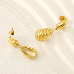 Elegant gold double teardrop textured earrings on white wavy background display
