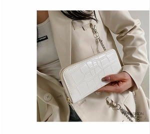 Close-up of white embossed PU leather long wallet with metallic chain and crocodile texture