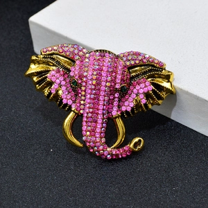 Broche éléphant dorée à strass roses sur un arrière-plan minimaliste élégant