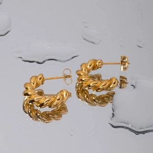 Elegant 18K gold plated stainless steel twisted hoop earrings on reflective water surface