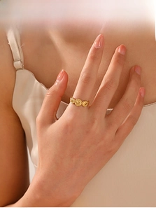 Detailed close-up of a vintage gold-plated geometric coin ring on a model's finger