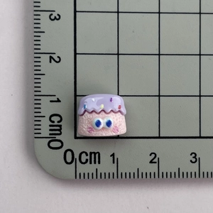 Detailed scale view of a miniature 1.2cm purple resin dessert charm with large blue eyes