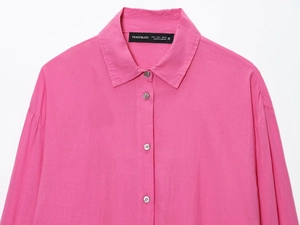 Close-up of bright pink cotton-linen shirt featuring classic collar and button details