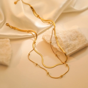 Double layer gold titanium steel necklace featuring a flat snake chain and beaded link style