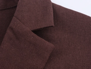 Close-up of the textured fabric and classic lapel stitching on a brown blazer