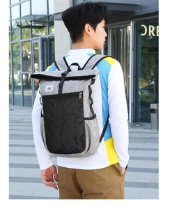 Outdoor lifestyle view of grey roll-top waterproof travel backpack with side mesh pockets