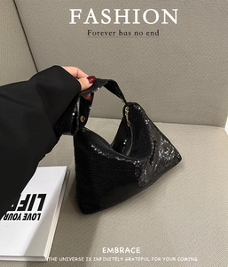 Détail du sac hobo à paillettes noires montrant la texture scintillante et le zip doré