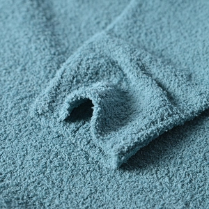 Detailed close-up of blue textured chenille knit fabric showing soft fiber texture