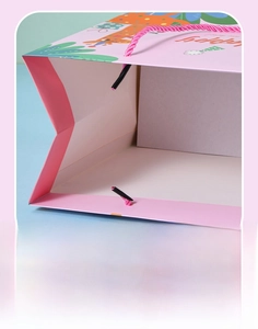 Detail of pink cartoon gift bag showing reinforced handle and thick bottom insert