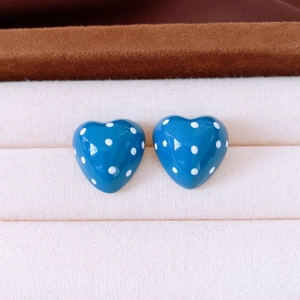Detailed close-up of blue polka dot heart earrings displayed in a premium jewelry box