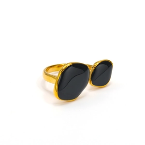 Detailed close-up of double irregular black stones on a gold open-style fashion ring