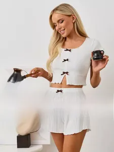 Détails de l'ensemble de détente en tricot blanc avec nœuds bruns et texture côtelée