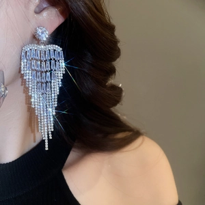 Long shimmering flower tassel earrings with multi-row rhinestones worn by a model