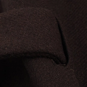 Close-up of deep coffee brown wool blend coat fabric showing heavy textured weave detail