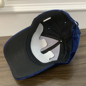 Detail view of the navy corduroy baseball cap interior with inner lining and support insert