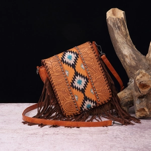 Close-up of bohemian leather crossbody bag with ethnic weaving and tassel details