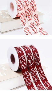 Detail of pink and burgundy satin ribbons with white love script for gift wrapping