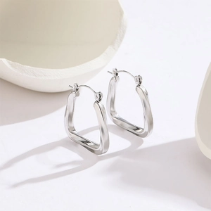 Minimalist silver irregular geometric titanium steel hoop earrings on white display