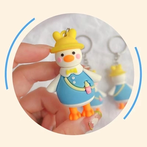Close-up of a cute yellow duck keychain held by hand featuring a unique tilted neck design