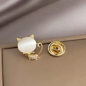 Elegant gold cat brooch with opal stone and sparkling cubic zirconia on silk fabric