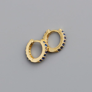 Detail of 925 sterling silver hoop earrings with blue zircon inlays and gold plating