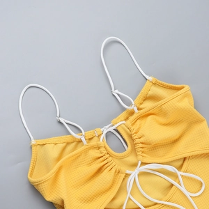 Détail de la maille gaufrée jaune du débardeur avec bretelles fines et nœud frontal