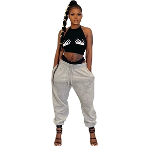 Detail of a black halter crop top featuring a white skeletal hand print on the chest