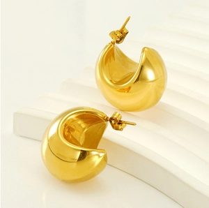 Macro shot of 18K gold plated teardrop earrings on a white corrugated display stand