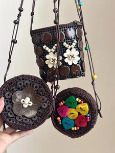Detail of bohemian handmade coconut shell mini crossbody bag with floral wood accents