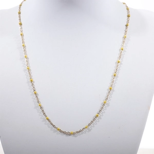 Detail of a thin gold beaded necklace with yellow enamel beads on a white neck display