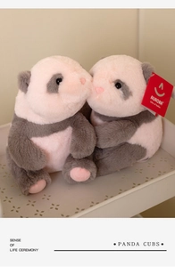 Detailed view of two soft panda cub plush toys in soft pink, grey and white colors