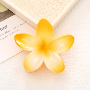 Detailed top view of a yellow gradient plumeria hair claw clip on a minimal tray