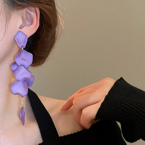 Detail of purple matte petal tassel earrings hanging elegantly on a female model