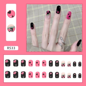 Macro-weergave van R533 roze en zwarte plaknagels met dambordpatroon en ster-motieven