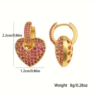 Macro detail of gold heart earrings with red zircons showing size and weight specs