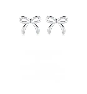 Close-up of polished S925 sterling silver bow knot stud earrings on white background